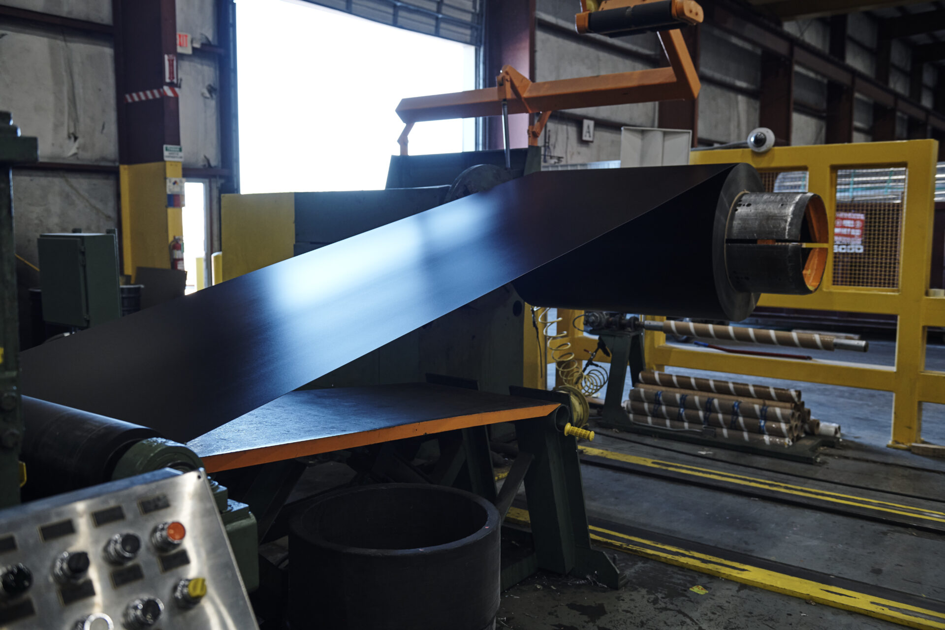 roll of black painted aluminum coil being unspooled